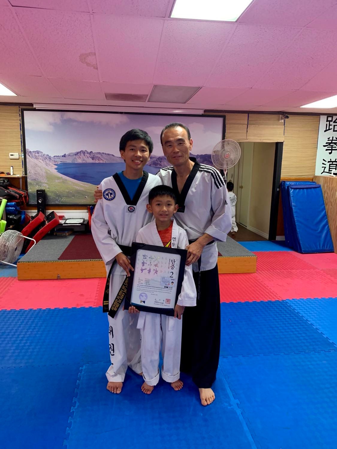 Master Tiger and Andrew with Philip's 2nd-degree black belt certificate